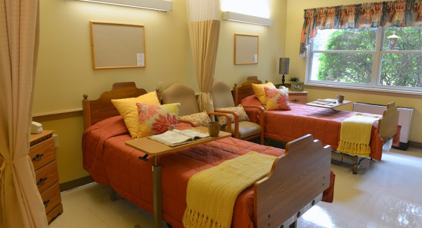 Private and semi-private room with bed and chairs